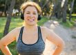 Woman and sports. Girl doing exercise for weight loss in the fresh air and laughing in camera after training.
