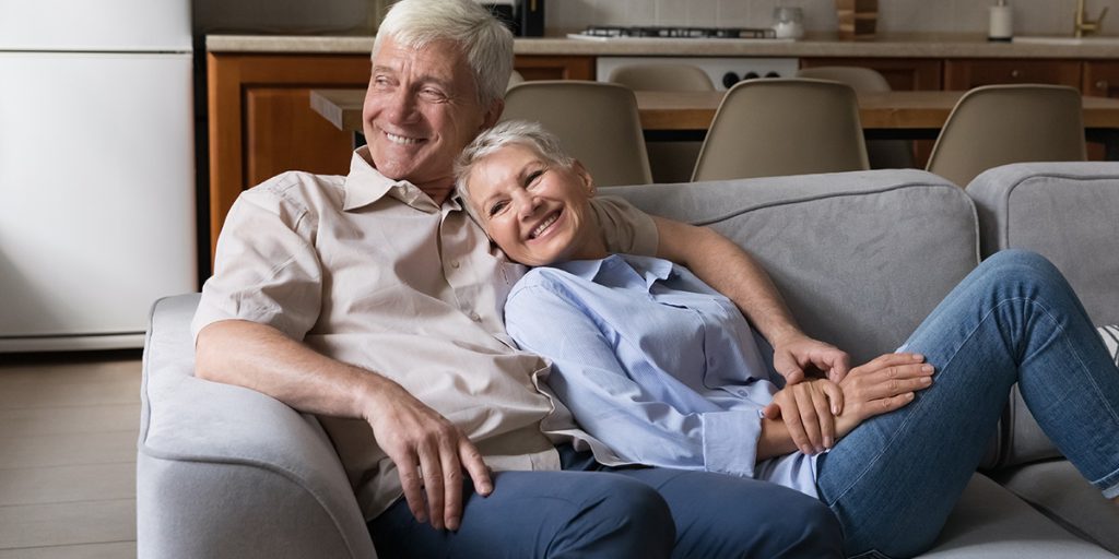 happy older couple sitting on couch together