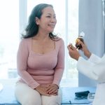 physician explains difference in bioidentical and synthetic hormones to female patient.