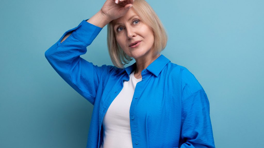 Woman in blue shirt, thoughtful pose.