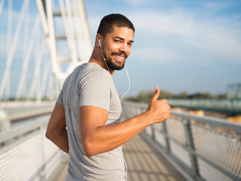 smiling-athlete-with-earphones-holding-thumbs-up-ready-training smiling-athlete-with-earphones-holding-thumbs-up-ready-training