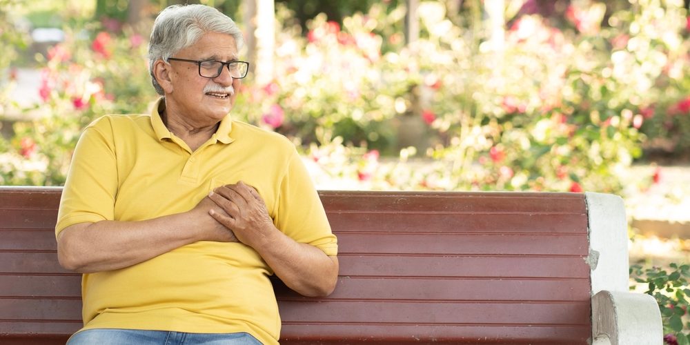 Man on bench having a heart attack