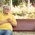 Man on bench having a heart attack