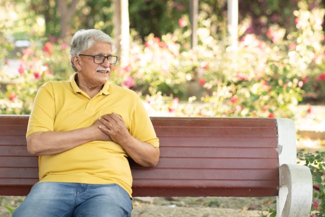 Man on bench having a heart attack